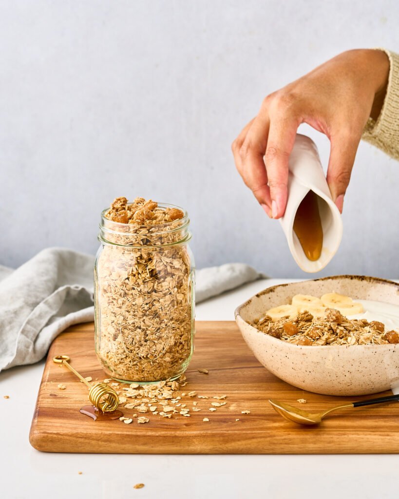 Granola in a bowl with maple syrup.